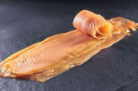 Truite entiere fumee tranche sur peau